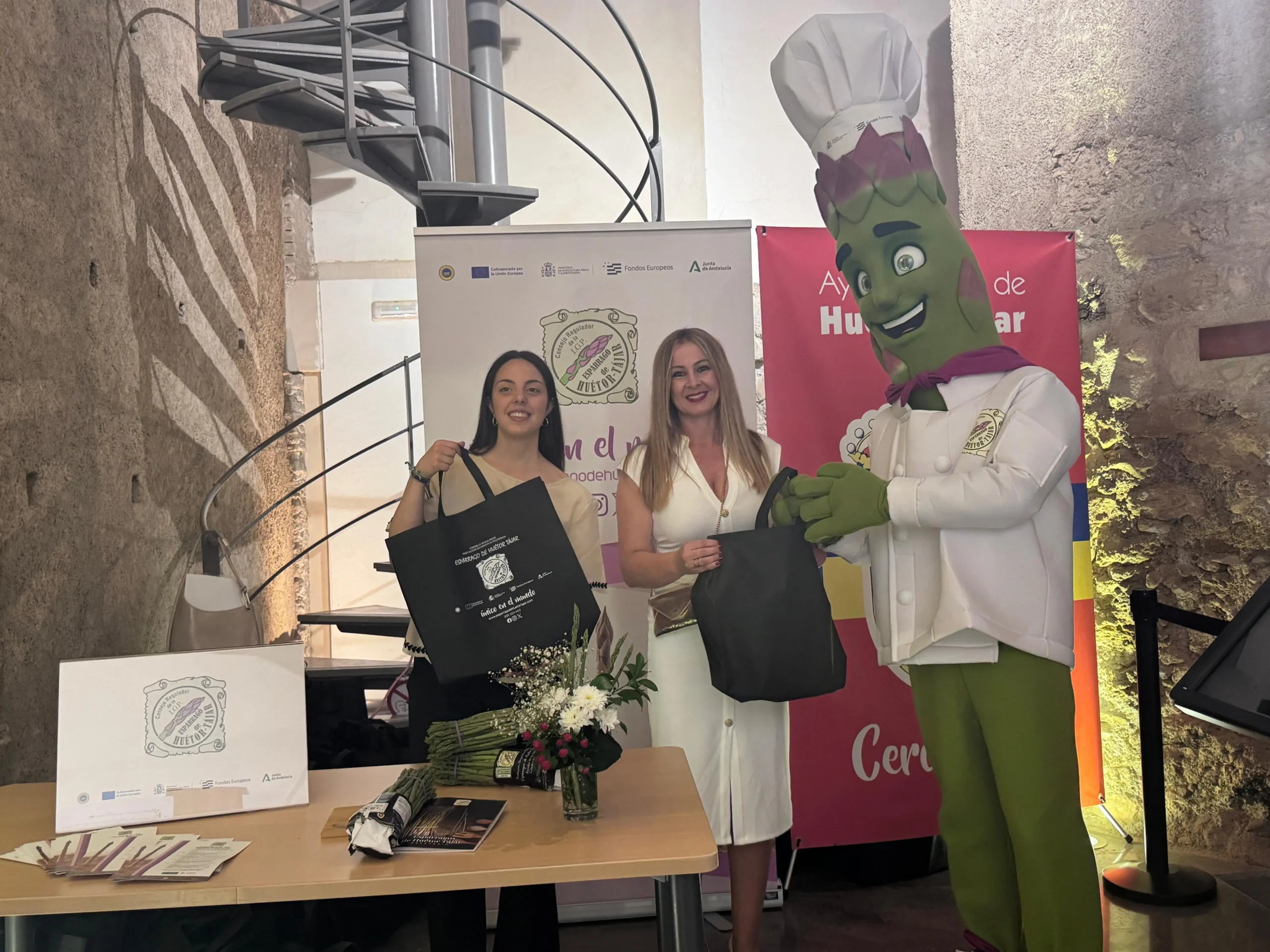 Representantes de la IGP Espárrago de Huétor Tájar junto a la mascota oficial en las VI Jornadas Orgullo de Nuestra Tierra.